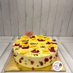 This is our much-loved Rasmalai Cake, a perfect example of our Indian fusion creations. We soak a soft, airy sponge in sweet, cardamom-infused milk and top it with delicate rasmalai pieces, pistachios, and rose petals for a truly decadent dessert.
