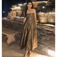 A client embodies pure elegance in her custom-designed strapless brocade dress at a destination event. The rich, paisley-patterned fabric and impeccable fit showcase our dedication to creating luxurious, memorable evening wear for any special occasion.