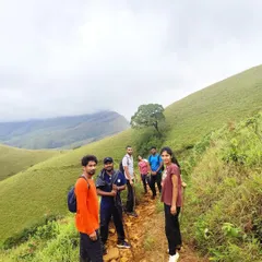 Our group hiking along a narrow path on the vast grasslands of Kudremukha. This shows the scale and beauty of the landscape.