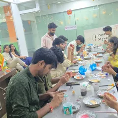 Colleagues get to sit together and focus on a creative task, painting traditional diyas for a festive celebration. It's a great way to foster relaxed interaction.