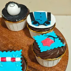 Another angle of the hobby-themed cupcakes, showing the fondant details for a biker's jacket and a pool lane marker.
