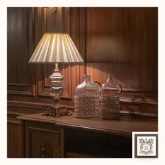 This transparent crystal table lamp is a study in classic elegance. Placed on a wooden console, its intricate base and striped shade refract light beautifully, adding a luxurious and dazzling effect to a formal living area.