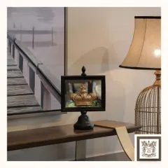 This "Crowning Glory" mirror, with its black frame and gold crown accent, adds a touch of regal charm to a console table. It's a playful yet sophisticated piece that makes a statement.