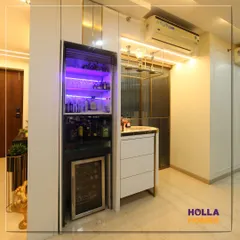 The hidden bar cabinet opens up to reveal a fully stocked bar with a mini-fridge and dramatic purple lighting, adding an element of surprise and luxury.