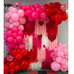 Get ready for love! This Valentine's Day backdrop features a red and pink streamer wall framed by a lush balloon arch with heart accents, perfect for a romantic celebration.