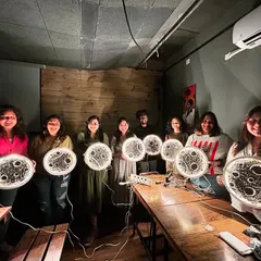 A group of proud creators with their finished moon lamps, all lit up in a dark room. The effect is absolutely breathtaking.