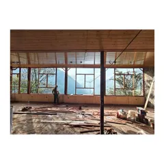 An in-progress view of the open pavilion. The design features a delicate butterfly roof that seems to float above the hills, creating a space that is sheltered yet completely open to the elements.