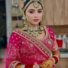 This bride opted for a vibrant pink and green lehenga. We complemented her outfit with soft pink makeup, green-accented jewelry, and an elegant floral bun to create a cohesive and fresh bridal look.