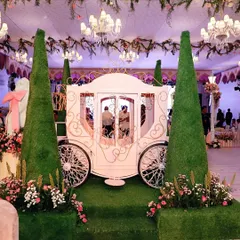 The fairytale carriage, illuminated under the soft glow of the venue's chandeliers, becomes the heart of the celebration. This is where we blend large-scale props with ambient lighting to create moments of pure magic.