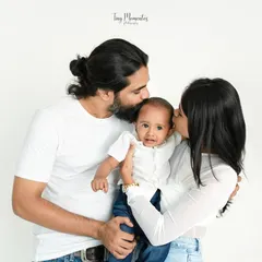 Surrounded by kisses. This tender moment between mom, dad, and baby is what family photography is all about.