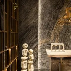 The reception desk features a stunning backdrop of book-matched marble, setting a tone of sophisticated luxury from the moment you enter. The abstract sculptures add an artistic, modern touch to the arrival experience.