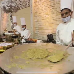 A chef preparing a dish on a large flat tawa at a live station. This method is perfect for a variety of vegetarian dishes and ensures the food is served piping hot.