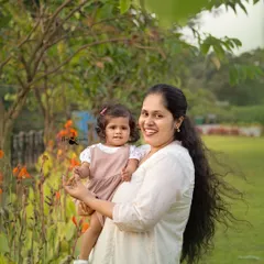 A beautiful, natural portrait of a mother holding her daughter. The soft outdoor light and genuine smiles make this a timeless family photograph.
