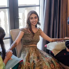 A beautiful, happy bride smiling as my team and I apply her full bridal mehendi. Being part of these joyous moments is what makes my work so special.