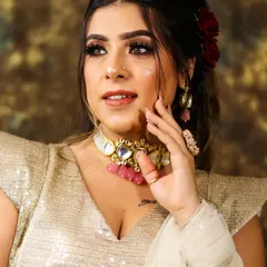 A glamorous party look featuring soft curls, red roses in the hair, and a beautiful smokey eye.