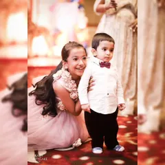 A candid shot of a brother and sister sharing a happy moment at a party. Capturing sibling love is one of our favorite things.