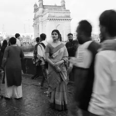 This shot at the Gateway of India uses a slow shutter speed to capture the motion of the crowd, making the model stand still in the middle of the chaos. It's a powerful storytelling technique for environmental portraits.