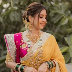 A radiant Maharashtrian bride in a stunning yellow and pink Nauvari saree. I created a soft, elegant updo to complement her traditional jewelry and nath, ensuring she felt comfortable and beautiful on her special day.