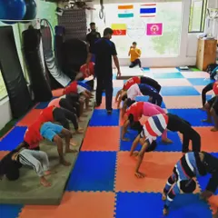 I'm supervising the class as they practice their backbends, or bridges. I ensure each child uses proper form to safely develop spinal flexibility and shoulder strength.