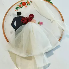 This hoop art captures a couple in Western wedding attire. The bride's veil and gown are crafted from delicate tulle fabric, adding a realistic and romantic touch.