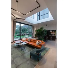 The open plan living space at the Nandi Hills residence, designed for relaxation and entertaining. An indoor planter brings nature inside, while a large skylight and expansive windows ensure the room is always connected to the outdoors.