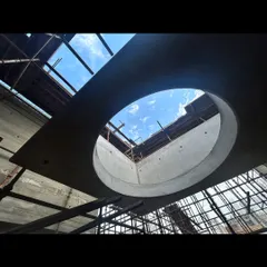 Looking up through a large circular oculus in the concrete roof slab of the Moradabad project. This element is designed to bring a dramatic column of light down into the interior space.