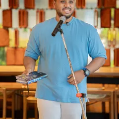 A poet holds his book during our Pride-themed open mic. The event was a testament to what community and pride sound like.