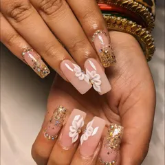 For the bride who loves glamour. This set features long, square-tipped extensions with 3D flowers, gold glitter, and rhinestone accents for a truly show-stopping look.