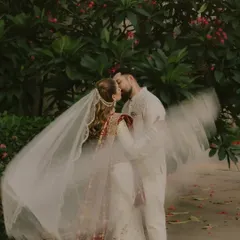 A dreamy, romantic kiss with the bride's veil creating a soft, ethereal blur. We love experimenting with motion and fabric to add a touch of magic to our couple portraits.