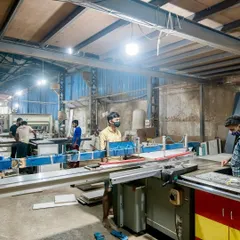 Behind every meticulously crafted kitchen is our dedicated factory team. Here you can see our skilled workers using precision machinery to ensure every component is cut and finished to perfection.