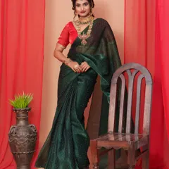 This stunning dark green organza saree, paired with a contrasting red blouse and traditional gold jewellery, creates a regal and timeless look perfect for a wedding or cultural event.