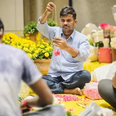 It’s the people behind the scenes that truly make an event. Here, one of our skilled artisans is carefully stringing fresh flowers, a craft that requires patience and precision.