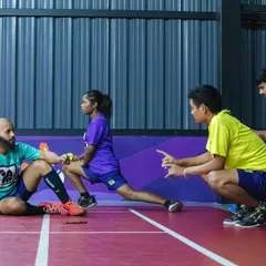 Team talk and stretching on the court. Our facilities are not just for playing; they're for communities to train, strategize, and grow together.