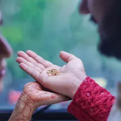 An intimate and symbolic shot of the groom presenting the wedding rings in his palm to the bride. This close-up captures the tenderness and significance of this promise.