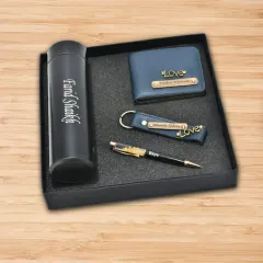 A sleek and professional gift set containing a personalized flask, a custom wallet, a matching keychain, and a name-engraved pen.
