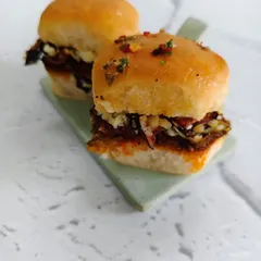 Golden, fluffy pav stuffed with a burst of flavor. Layers of spiced goodness, crunchy textures, and a buttery glaze come together in every bite of this indulgent creation.