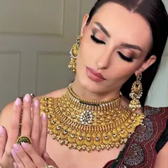 A close-up on the beautiful details of the jewelry and the soft, glamorous makeup. The shimmering eyeshadow and glossy lips create a look of pure luxury.