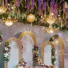 A grand view of the purple-themed stage. Golden arches, a ceiling of hanging wisteria, and magnificent chandeliers create a setting of pure opulence and modern royalty.