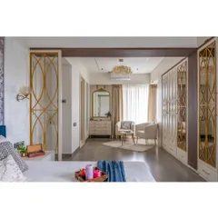 This perspective from the bed showcases the elegant seating area and custom wardrobes. The gold-inlay partition adds a decorative touch while subtly dividing the space.