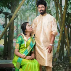 A classic pre-wedding portrait of a couple in traditional attire, set against a bamboo grove. The natural framing and soft light create a serene and timeless photograph.