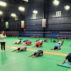 An instructor guides our athletes through mindful movements during a yoga session on our badminton courts. These sessions focus on body awareness and proprioception, allowing players to move with greater precision and control during a match.