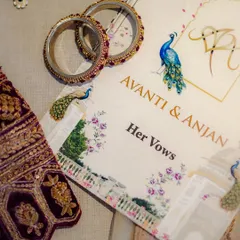 The details that tell the story. A flat-lay of the wedding invitation suite, the bride's vows, and her bangles.