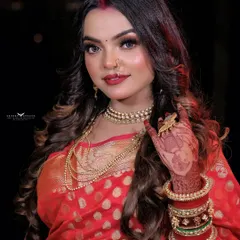 A classic Karwa Chauth portrait, capturing the festive spirit with a model in a red saree, complete with traditional jewelry and makeup.