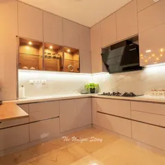 An L-shaped modular kitchen that perfectly blends function and style. The space features handle-less glossy cabinets, a marble-effect backsplash, and a compact, foldable breakfast table for quick meals.