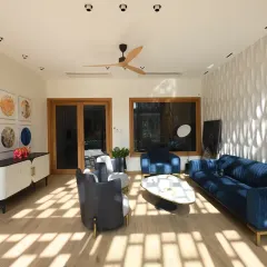 Sunlight filters through the intricate design of the front elevation screens in the Screen House, casting dynamic patterns on the living room floor and walls. As the day unfolds, these shifting shadows animate the space.