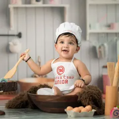 Introducing the Master Chef Junior. This creative themed portrait shows how we use playful setups and props, like a chef's hat and wooden utensils, to capture your baby's budding personality in a fun and unique way.