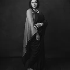 A full-length portrait in black and white, showcasing the elegant, modern drape of the saree. The image is both classic and contemporary.