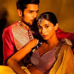 An intimate and artistic portrait of a couple. The bride's makeup features a traditional maang tikka and glowing skin, while the groom's look is clean and defined, creating a beautiful, cohesive image.