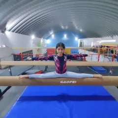 Balance, focus, and a smile. One of our intermediate gymnasts mastering the split on the balance beam, a fundamental skill in artistic gymnastics that builds incredible confidence.