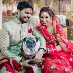 A beautiful wedding day portrait of the bride, groom, and their beloved pug. This photo is a wonderful way to include the whole family in the celebration.
